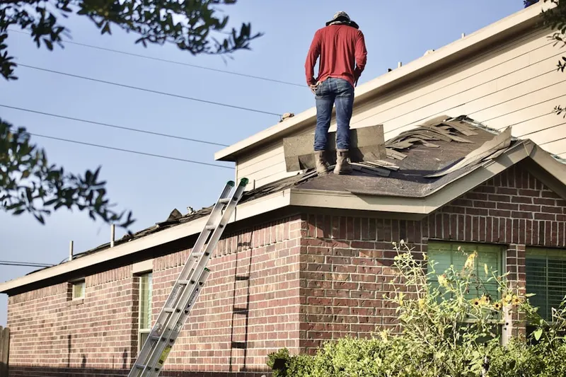 Professional roofer working on a residential roof in Draco